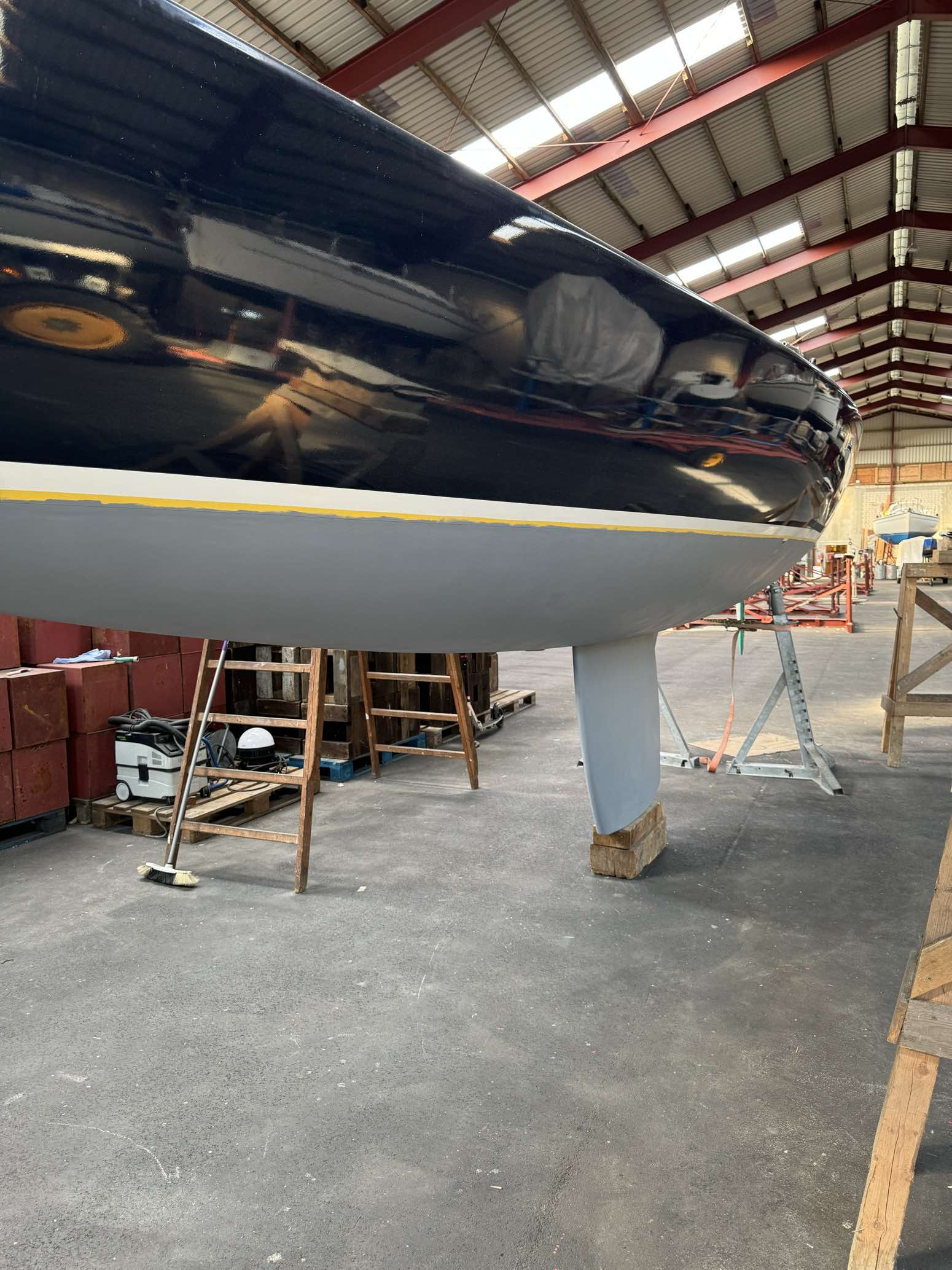 Frisch lackierter Yachtrumpf in der Werfthalle